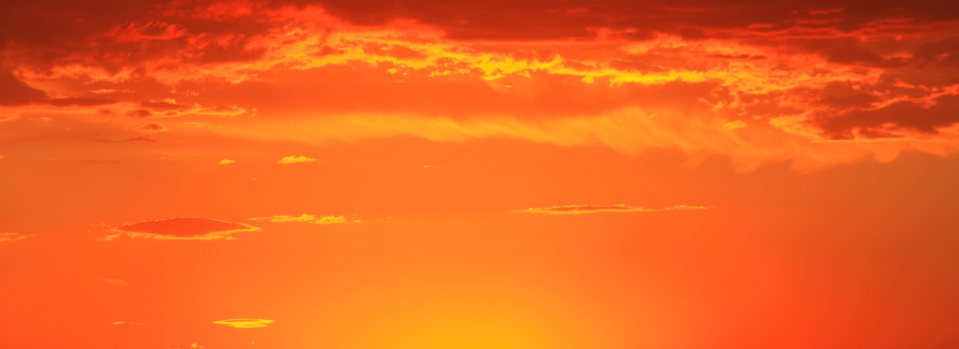 Brilliant orange sunset with tiny cloud streaks